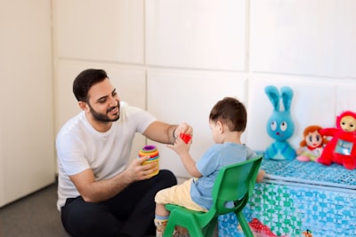 Adult playing with a child in a supportive therapy or practice setting.